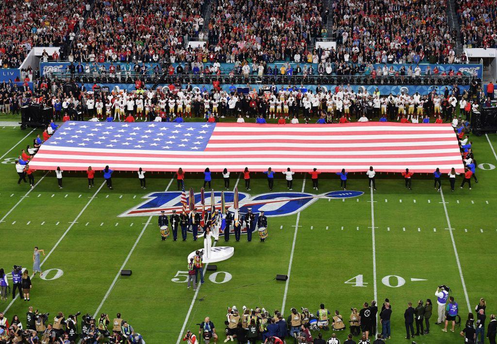 With the giant American flag unfurled behind her, Demi Lovato sings the National Anthem. (©Getty Images | <a href="https://www.gettyimages.com/detail/news-photo/singer-demi-lovato-sings-the-national-anthem-during-super-news-photo/1198185511?adppopup=true">ANGELA WEISS</a>)