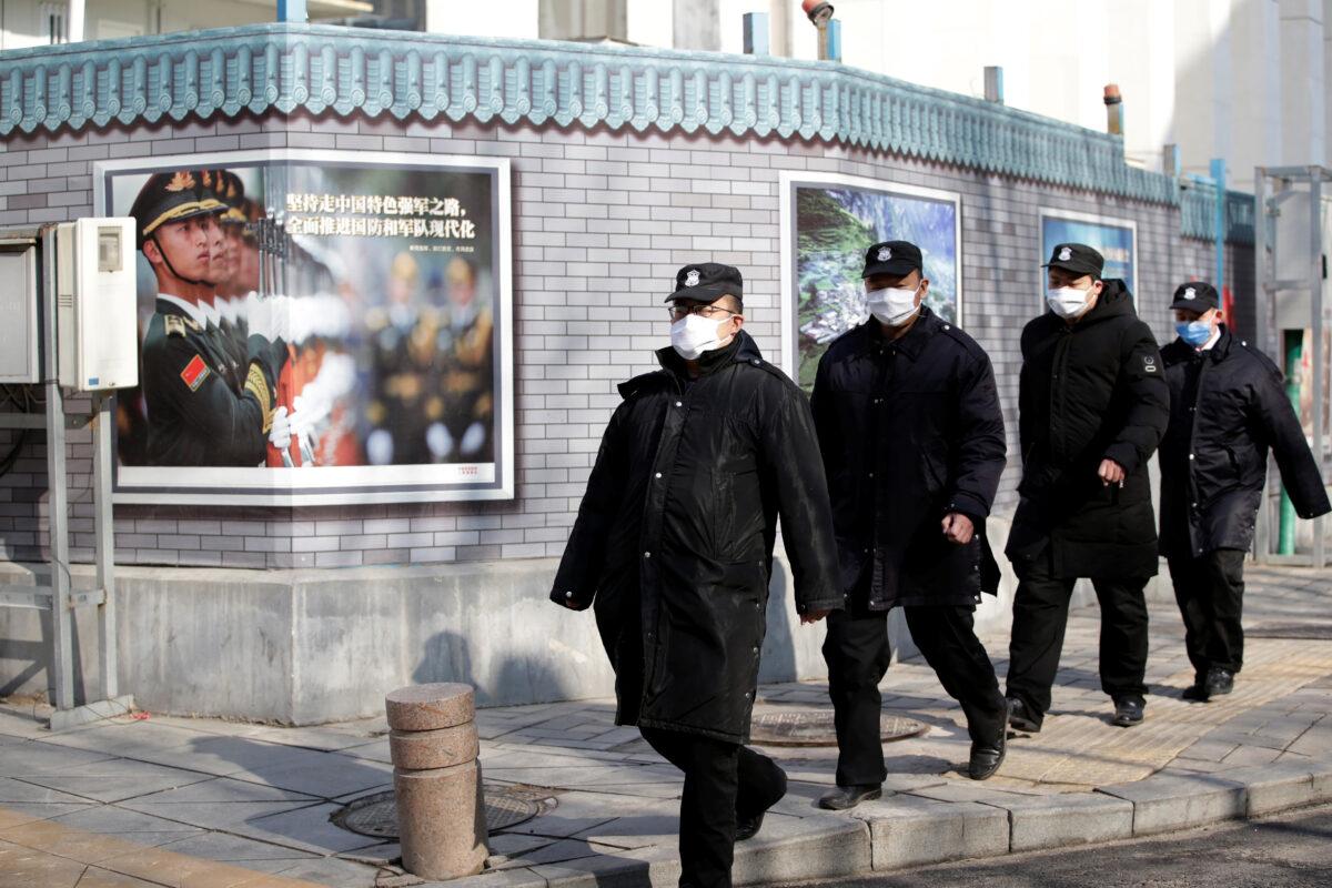 Security personnel wearing masks walk along the Financial Street in central Beijing, China, as the country is hit by an outbreak of the new coronavirus on Feb. 3, 2020. (Jason Lee/Reuters)