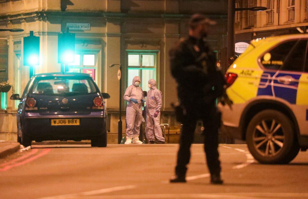 Police officers and a forensic officer near the site where a man was shot by armed officers in Streatham, south London, Britain, on Feb. 2, 2020. (Simon Dawson/Reuters)