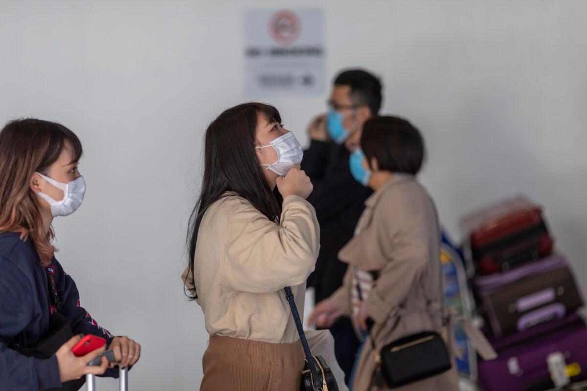 Travelers arrive at LAX Tom Bradley International Terminal wearing medical masks for protection against the novel coronavirus outbreak in Los Angeles, Calif. on Feb. 2, 2020. (David McNew/Getty Images)