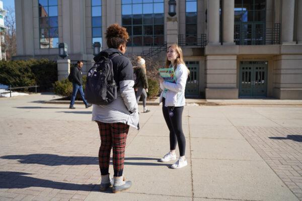 Taylor Huber talks to a student about why she will be caucusing for Elizabeth Warren on campus at the University of Iowa, Feb. 3, 2020. (Cara Ding/The Epoch Times)