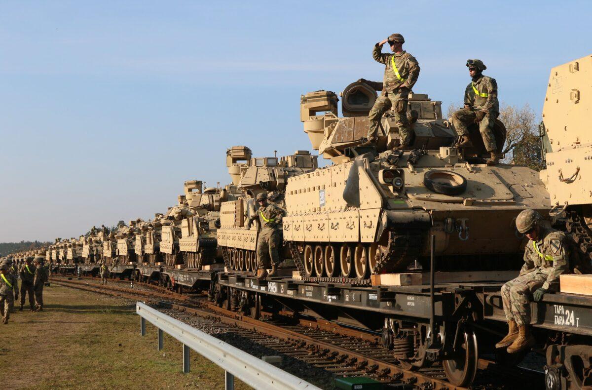 Members of the U.S. Army 1st Division 9th Regiment 1st Battalion unload heavy combat equipment, including Abrams tanks and Bradley fighting vehicles, at the railway station near the Pabrade military base in Lithuania, on Oct. 21, 2019. (Petras Malukas/AFP via Getty Images)