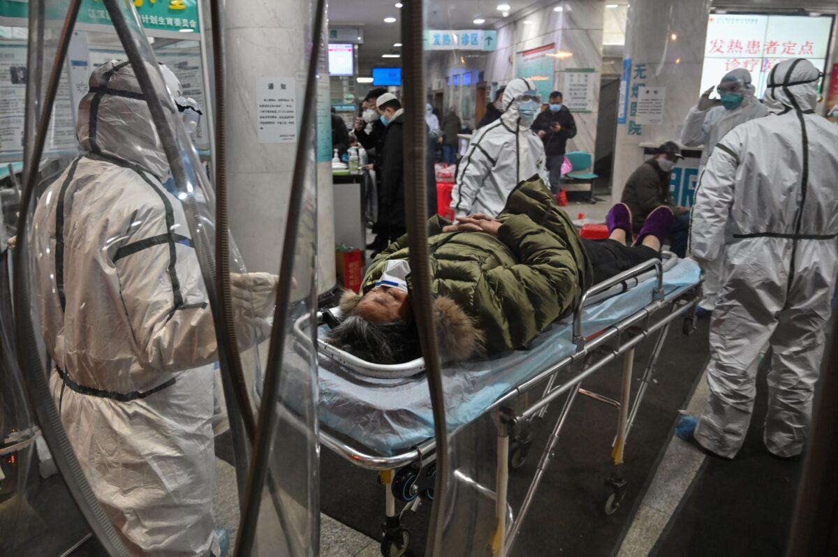 Medical staff members wearing protective clothing arrive with a patient at the Wuhan Red Cross Hospital in Wuhan, China on Jan. 25, 2020. (Hector Retamal/AFP via Getty Images)