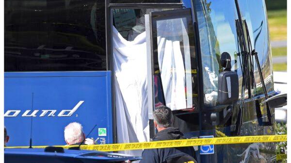 Coroner’s officials work behind a drape to remove the body of one person who was killed when a gunman opened fire aboard a packed Greyhound bus, and wounded five others before the driver pulled over onto the shoulder and the killer got off, In Lebec, Calif., some 75 miles north of Los Angeles, on Feb. 3, 2020. (Jayne Kamin-Oncea/AP Photo)