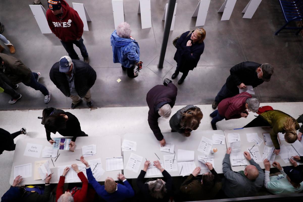 Caucus goers check in at a caucus at Roosevelt High School in Des Moines, Iowa, on Feb. 3, 2020. (Andrew Harnik/AP Photo)