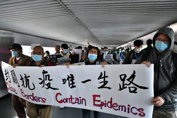Protesters hold up banners and placards during a "flash mob" gathering to demand the government close its border with mainland China to reduce the spread of the deadly SARS-like virus to Hong Kong, China, on Feb. 3, 2020. (Anthony Wallace/AFP via Getty Images)