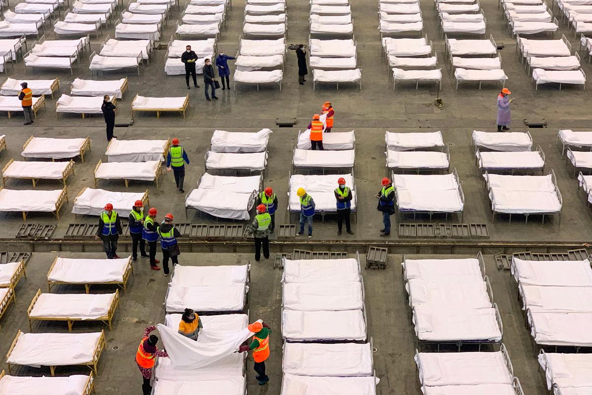 Workers set up beds at a Fangcang hospital in Wuhan, China, on Feb. 4, 2020. (STR/AFP via Getty Images)