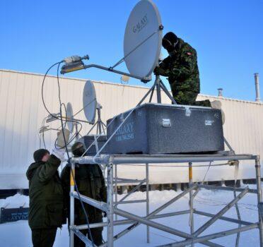 Aerial electronic sensor operators make final adjustments to the communications systems used during Operation Nunalivut in Hall Beach, Nunavut, on Feb. 22, 2017. (PO2 Belinda Groves Task Force Imagery Technician)