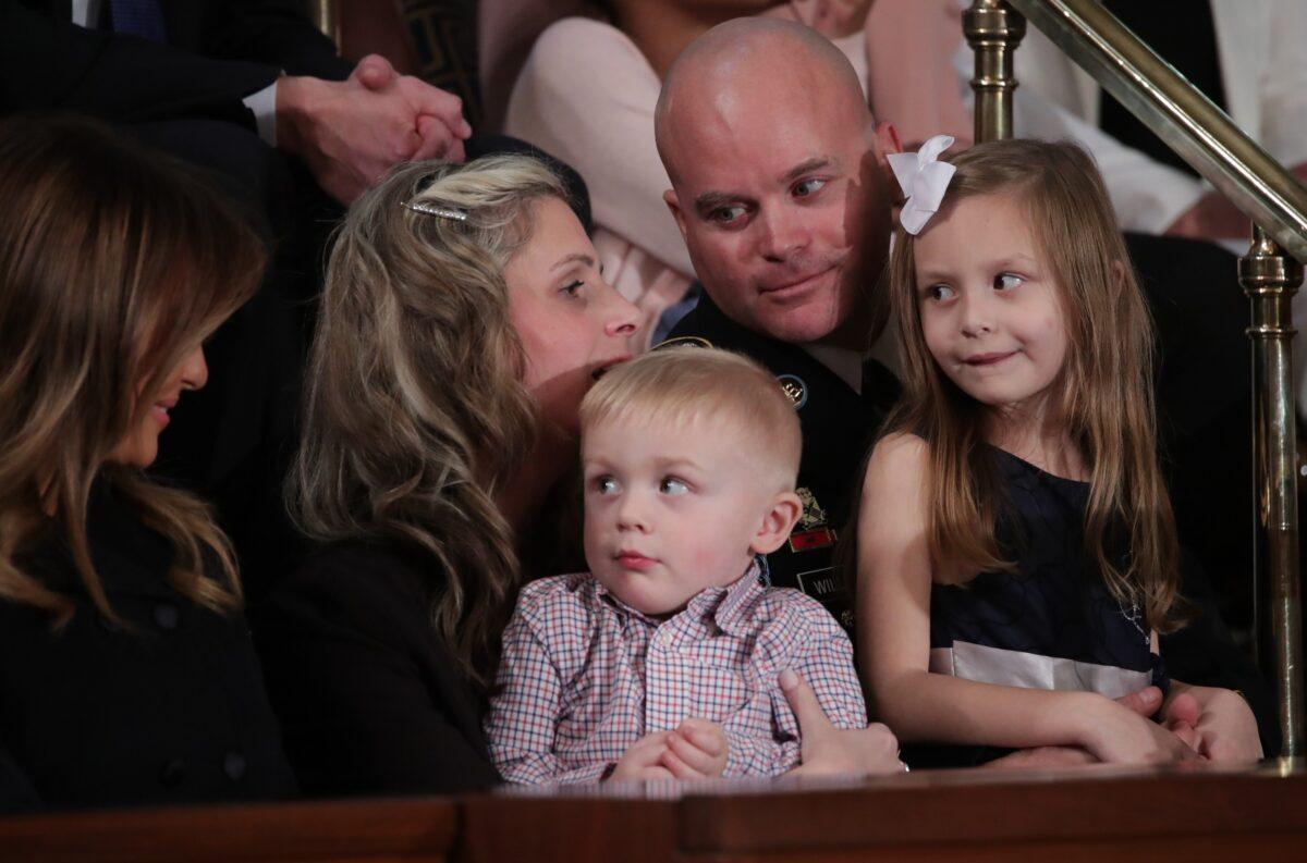 Sgt. 1st Class Townsend Williams sits with his wife Amy Williams and children after he surprised her from a deployment in Afghanistan to attend President Donald Trump's State of the Union address to a joint session of the U.S. Congress in the House Chamber of the U.S. Capitol in Washington on Feb. 4, 2020. (Tom Brenner/Reuters)