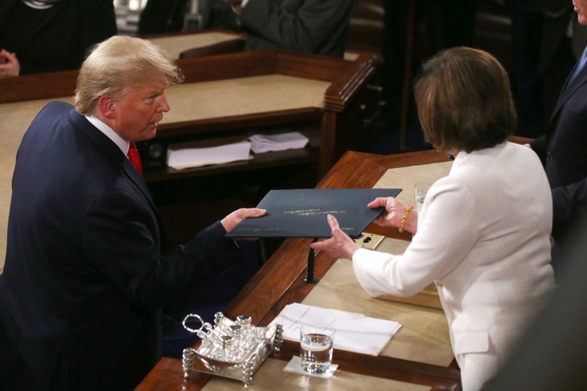 President Donald Trump hands House Speaker Nancy Pelosi (D-Calif.) a copy of his State of the Union speech before the State of the Union address in the chamber of the U.S. House of Representatives in Washington on Feb. 4, 2020. (Mario Tama/Getty Images)