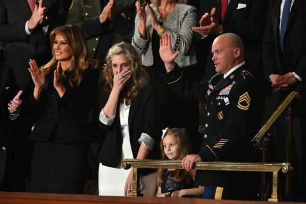 Sgt Townsend Williams (R) waves next to his children after returning from deployment in Afghanistan as his wife Amy (2L) looks on during the State of the Union address at the U.S. Capitol on Feb. 4, 2020. (MANDEL NGAN/AFP via Getty Images)