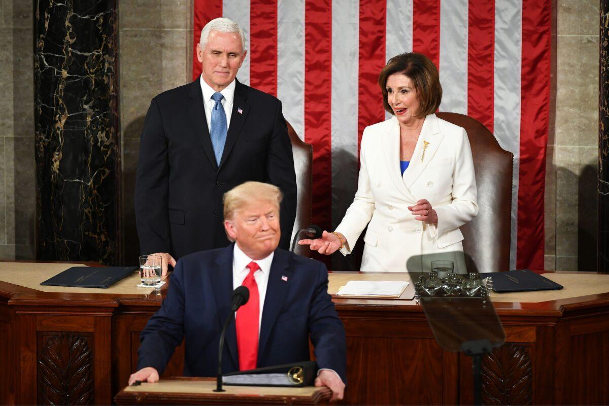 Vice President Mike Pence (L) watches as House Speaker Nancy Pelosi (D-Calif.) reacts after reaching out to shake hands with President Donald Trump as he arrives to deliver the State of the Union address in the House chamber of the U.S. Capitol in Washington, on Feb. 4, 2020. (Mandel Ngan/AFP via Getty Images)