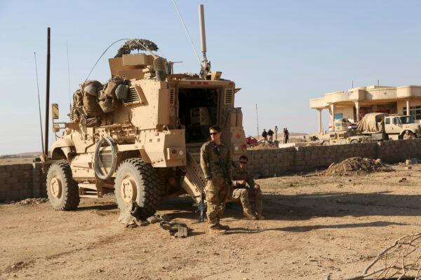 U.S. Army soldiers stand outside their armored vehicle on a joint base shared with the Iraqi army south of Mosul, Iraq on Feb. 23, 2017. (Khalid Mohammed/AP)