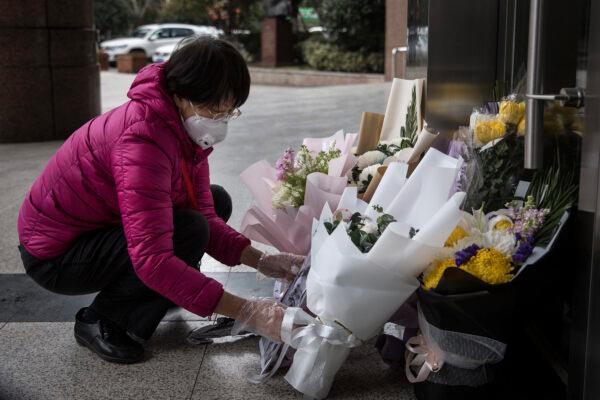A resident brings a bouquet of flowers to pay tribute to Dr. Li Wenliang at Li's hospital in Wuhan, China on Feb. 07,2020. (Getty Images)