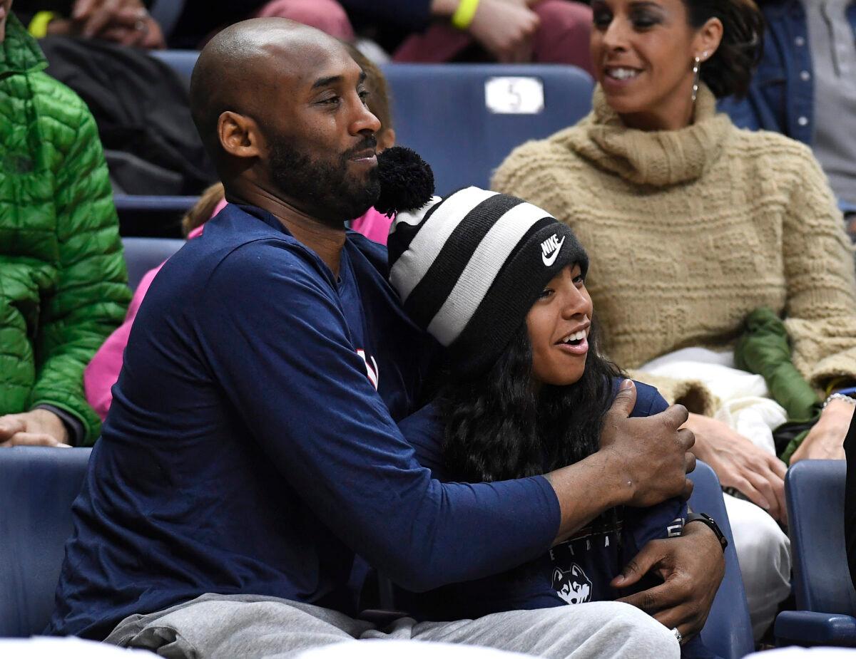 Kobe Bryant and his daughter Gianna watch the first half of an NCAA college basketball game between Connecticut and Houston in Storrs, Conn., on March 2, 2019. (Jessica Hill/AP Photo)