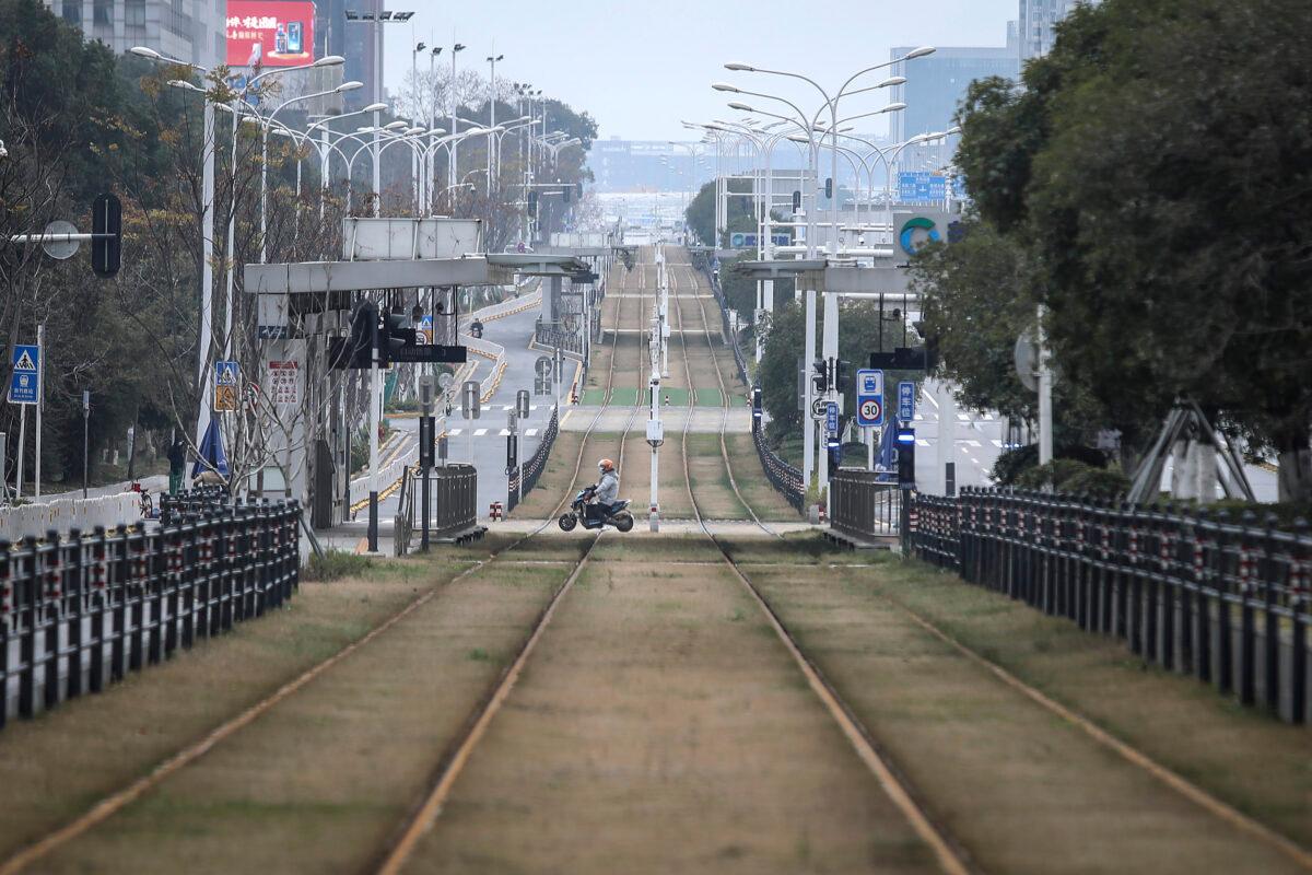 A resident rides a motorbike across an empty track in Wuhan, Hubei Province, China on Feb. 7, 2020. Starting from Jan. 23, 2020, Wuhan was placed under strict lockdown for 76 days. (Getty Images)