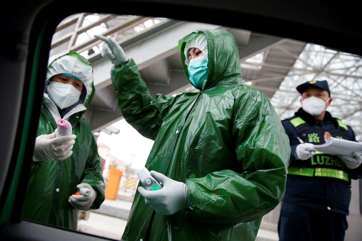 Medical and security workers stand at a checkpoint to screen for the new coronavirus in Anqing, Anhui province, China on Feb. 6, 2020. (Thomas Peter/Reuters)