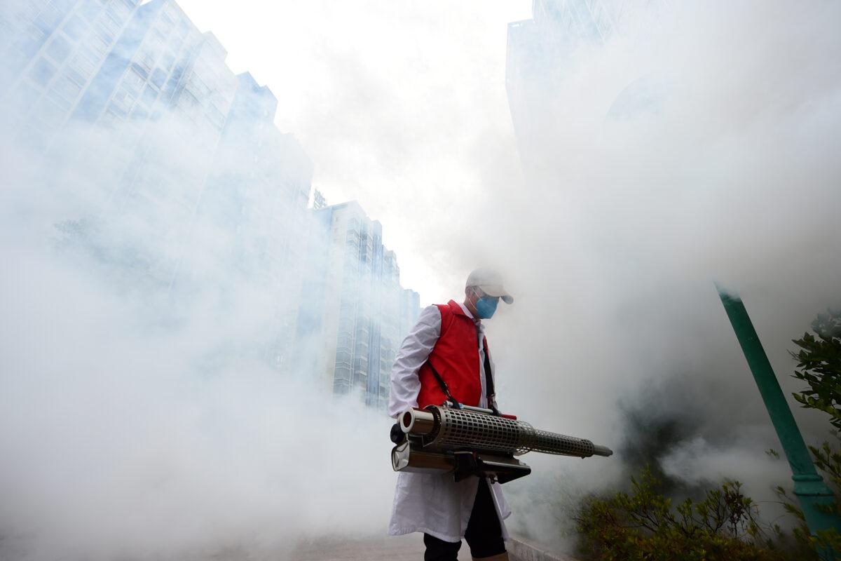 A volunteer disinfects a residential compound to prevent and control the new coronavirus, in Ganzhou, Jiangxi province, China on Feb. 6, 2020. (China Daily via Reuters)