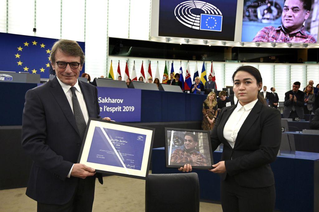 European Parliament President David-Maria Sassoli (L) stands next to Jewher Ilham, who is holding a portrait of her father during the award ceremony for his 2019 European Parliament's Sakharov human rights prize. (FREDERICK FLORIN/AFP via Getty Images)