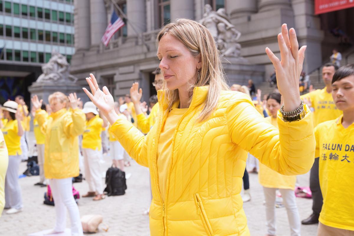 A woman practices the exercises of the Falun Gong practice near Battery Park in Manhattan during World Falun Dafa Day on May 13, 2015. (Benjamin Chasteen/The Epoch Times)
