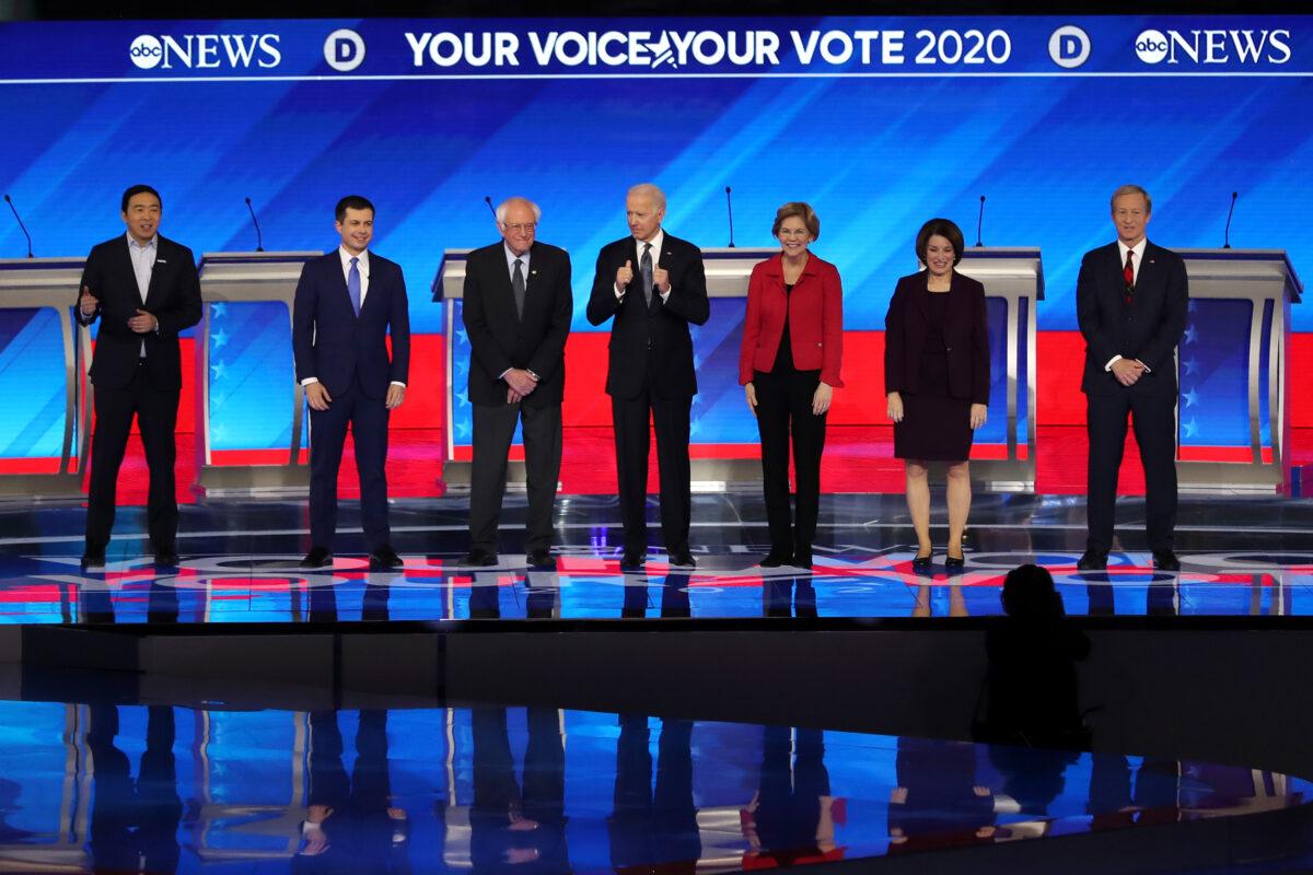 (L-R) Democratic presidential candidates Andrew Yang, former South Bend Mayor Pete Buttigieg, Sen. Bernie Sanders (I-Vt.), former Vice President Joe Biden, Sen. Elizabeth Warren (D-Mass.), Sen. Amy Klobuchar (D-Minn.), and Tom Steyer stand on stage at St. Anselm College in Manchester, New Hampshire, on Feb. 7, 2020. Neither Yang, who dropped out of the race, or Steyer, who failed to qualify, will be on the stage in Nevada on Feb. 19. (Joe Raedle/Getty Images)