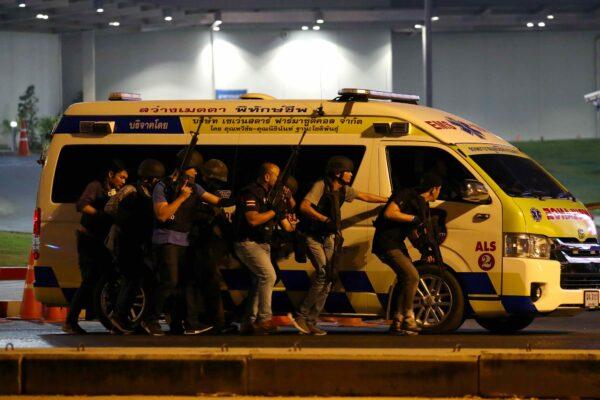 Thailand security forces take cover behind an ambulance as they chase a shooter hidden in a shopping mall after a mass shooting in front of the Terminal 21, in Nakhon Ratchasima, Thailand, on Feb. 9, 2020. (Athit Perawongmetha/Reuters)