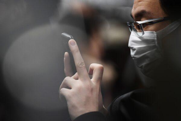A commuter wearing a face mask rides a metro train in Tokyo on Feb. 8, 2020. (Charly Triballeau/AFP via Getty Images)
