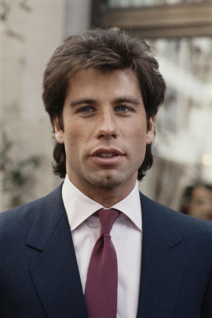 John Travolta promoting the release of his film "Staying Alive" at the Inn on the Park Hotel in London, England, in 1983 (©<a href="https://www.gettyimages.com/detail/news-photo/headshot-of-john-travolta-us-actor-promoting-the-release-of-news-photo/117619237?adppopup=true">Getty Images</a>)