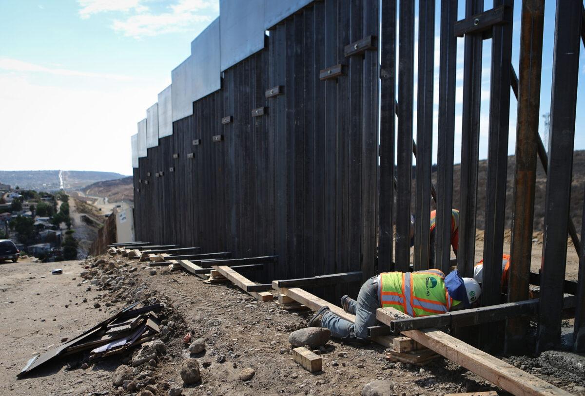A construction worker installs new fencing along the U.S.–Mexico border fence in Tijuana, Mexico, on July 21, 2018. (Mario Tama/Getty Images)