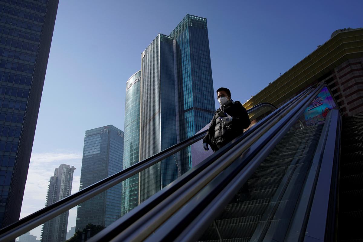 A man wearing a face mask rides an escalator at the Lujiazui financial district in Pudong, Shanghai, China on Feb. 10, 2020. (Aly Song/Reuters)