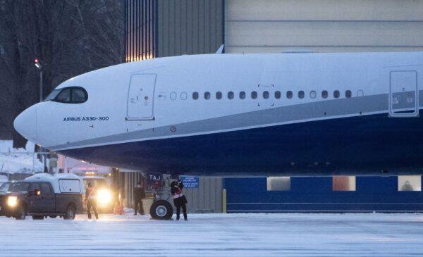 Crews attend to a plane carrying 176 Canadian citizens from the centre of the global novel coronavirus outbreak in Wuhan, China, after it arrived at CFB Trenton, in Trenton, Ont., on Feb. 7, 2020. (The Canadian Press/Justin Tang)