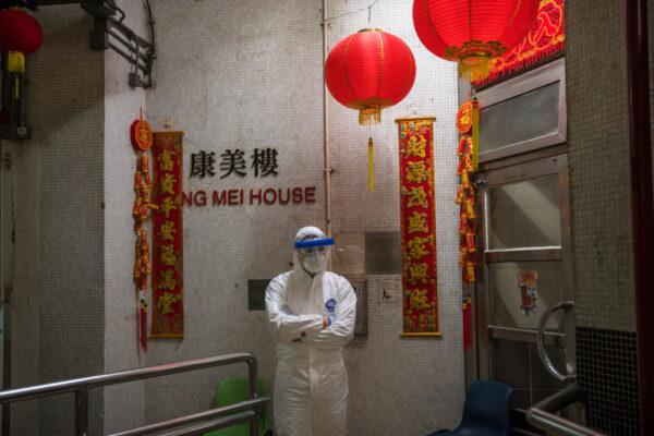 An official wearing protective gear stands guard outside an entrance to the Hong Mei House residential building at Cheung Hong Estate in the Tsing Yi district, Hong Kong on Feb. 11, 2020. (Billy H.C. Kwok/Getty Images)