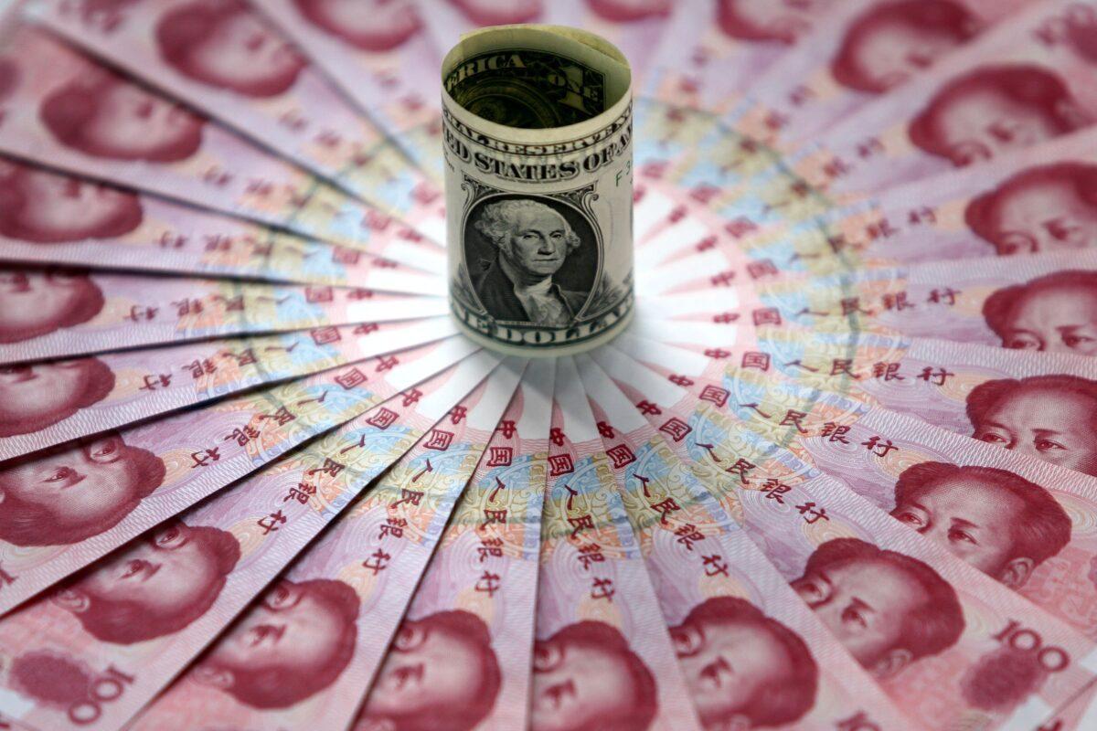 One dollar and 100 yuan notes are on display at a bank in Beijing, China, on May 15, 2006. (China Photos/Getty Images)
