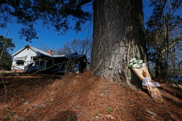 A bouquet of carnations rests aside a tree outside the charred remains of a fatal fire in Clinton, Miss., on Feb. 8, 2020. (Rogelio V. Solis/AP Photo)
