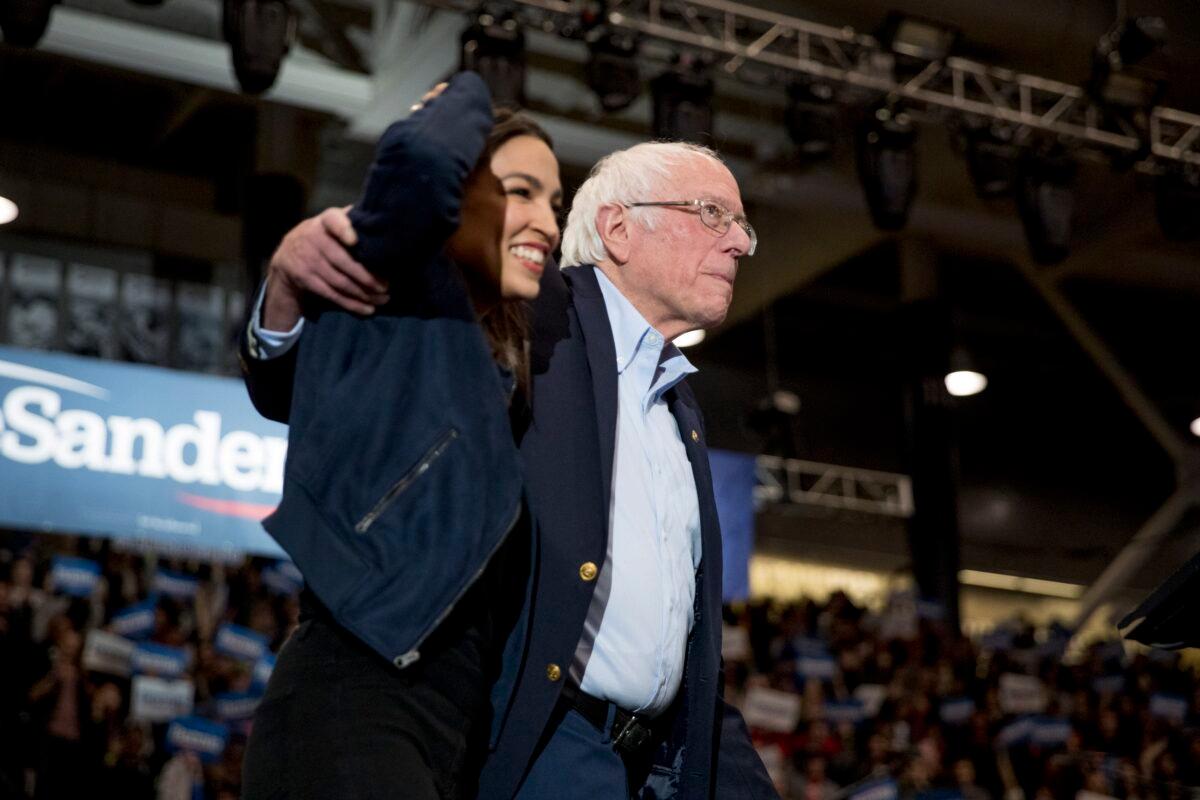 Democratic presidential candidate Sen. Bernie Sanders (I-Vt.) accompanied by Rep. Alexandria Ocasio-Cortez (D-N.Y.) takes the stage at campaign stop at the Whittemore Center Arena at the University of New Hampshire in Durham on Feb. 10, 2020. (Andrew Harnik/AP Photo)