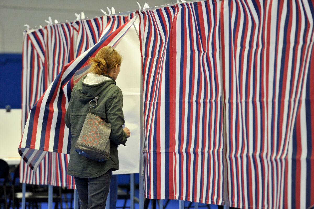 A women enters a voting booth at the Ward Five Community Center during the New Hampshire primary in Concord, N.H., on Feb. 11, 2020. (Joseph Prezioso/AFP via Getty Images)