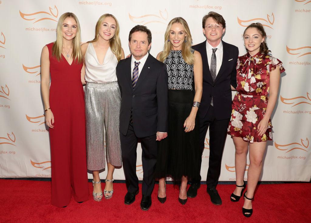 (L–R) Twins Schuyler and Aquinnah, Michael J. Fox, Tracy Pollan, Sam, and Esme on the red carpet of A Funny Thing Happened On The Way To Cure Parkinson's benefiting The Michael J. Fox Foundation at the Hilton New York on Nov. 10, 2018 (©Getty Images | <a href="https://www.gettyimages.com/detail/news-photo/schuyler-frances-fox-aquinnah-kathleen-fox-michael-j-fox-news-photo/1060100862?adppopup=true">Cindy Ord</a>)