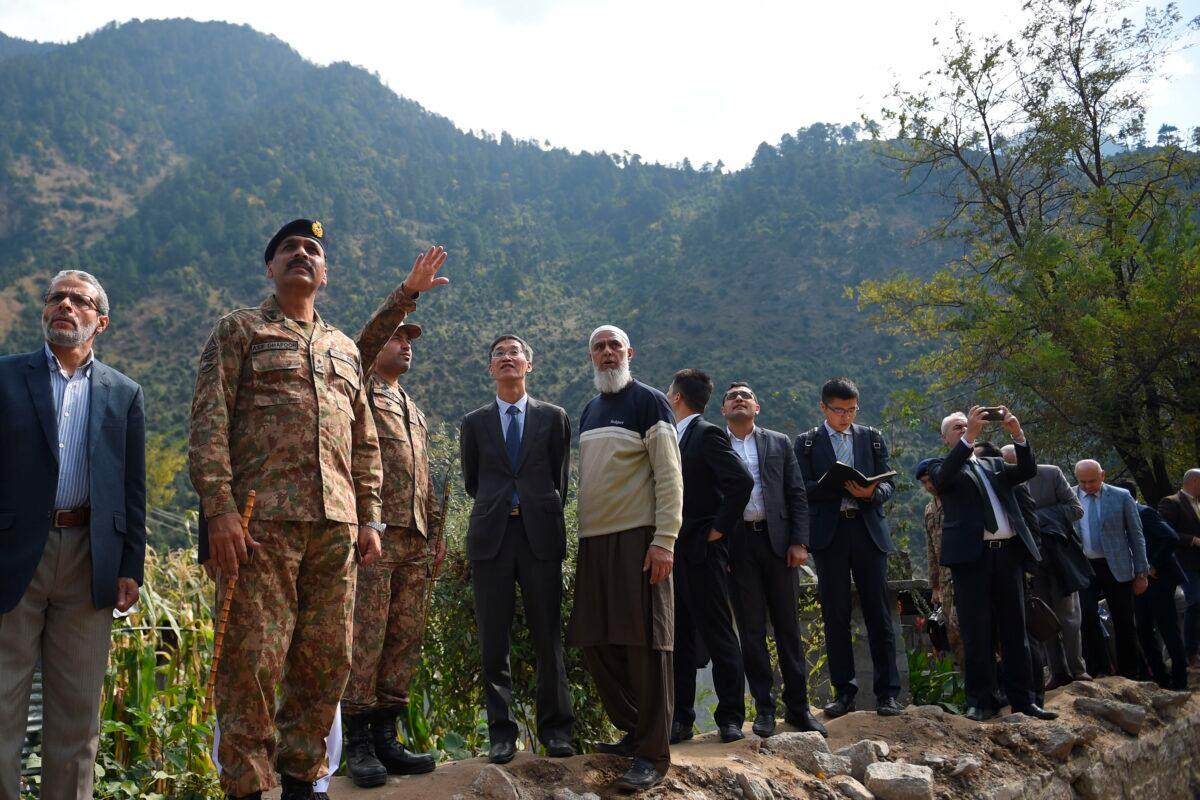 A Pakistani army officer (3L) briefs Chinese Ambassador to Pakistan Yao Jing (4L) and Pakistani army Major General Asif Ghafoor (2L) and foreign diplomats during their visit at a cross border shelling affected area in Jura, a village of Neelum valley in Pakistan-administered Kashmir on Oct. 22, 2019. (Farooq Naeem/AFP via Getty Images)