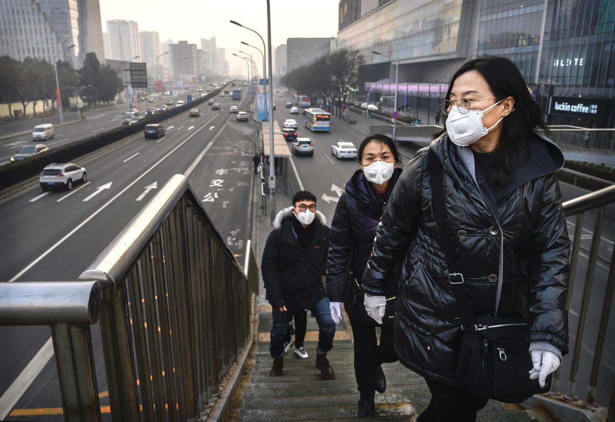 People wear protective masks as they cross a footbridge at a mall in Beijing, China, on Feb. 11, 2020. (Kevin Frayer/Getty Images)