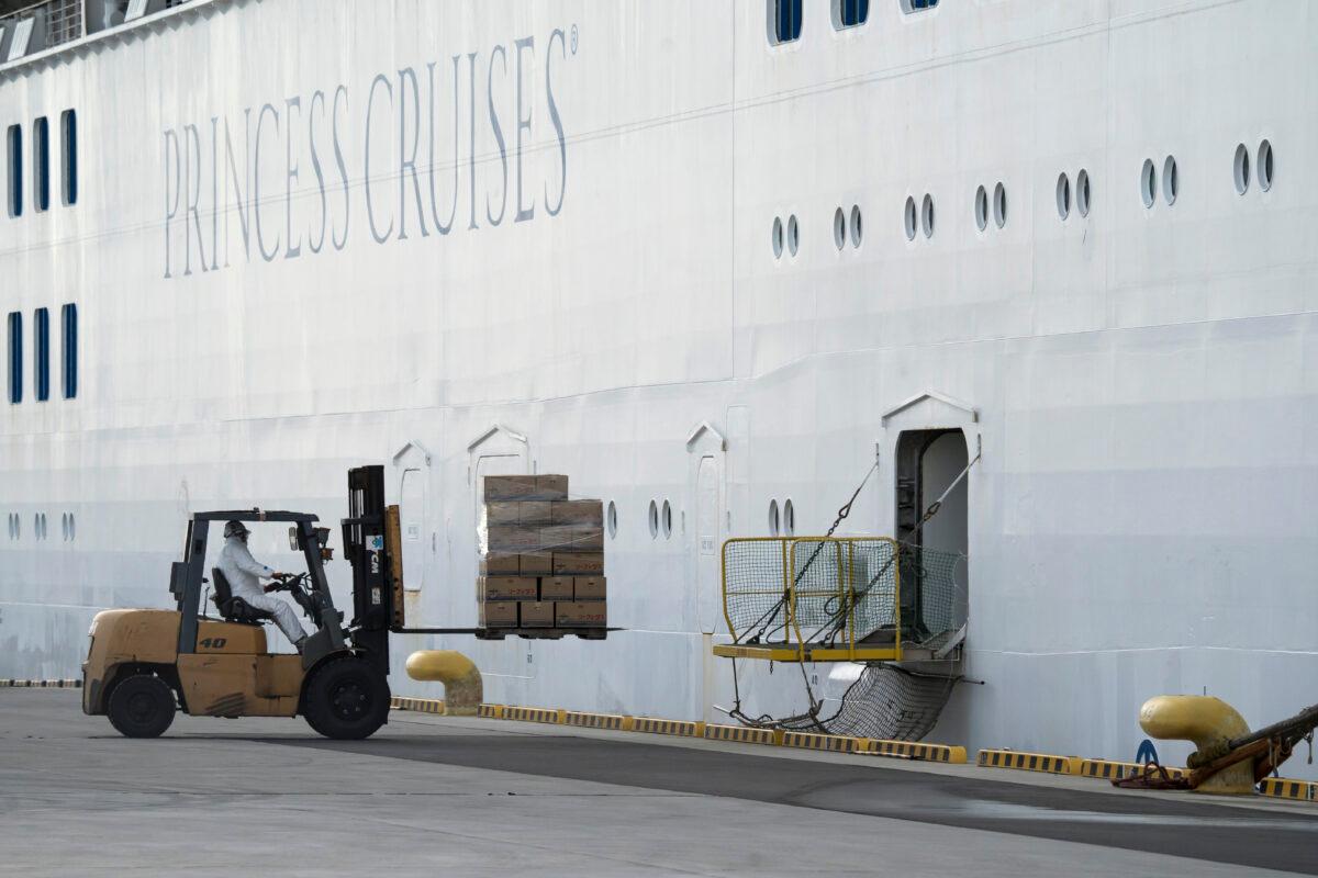 A worker wearing a mask and a protective suit operates a forklift to load boxes containing food to the Diamond Princess cruise ship, which is quarantined in Yokohama, Japan, on Feb. 12, 2020. (Tomohiro Ohsumi/Getty Images)