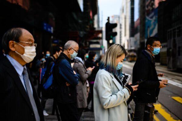 Pedestrians wear face masks as they walk on a footbridge in Hong Kong on Feb. 12, 2020. (Anthony Wallace/AFP via Getty Images)