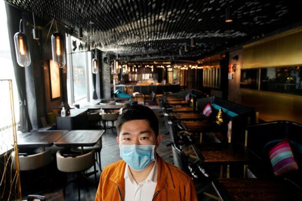 Bill Hu, founder and CEO of Seul & Seul restaurant, wears a mask and poses for pictures in downtown Shanghai, China, as the country is hit by an outbreak of a new coronavirus, on Feb. 12, 2020. (/Aly Song/Reuters)