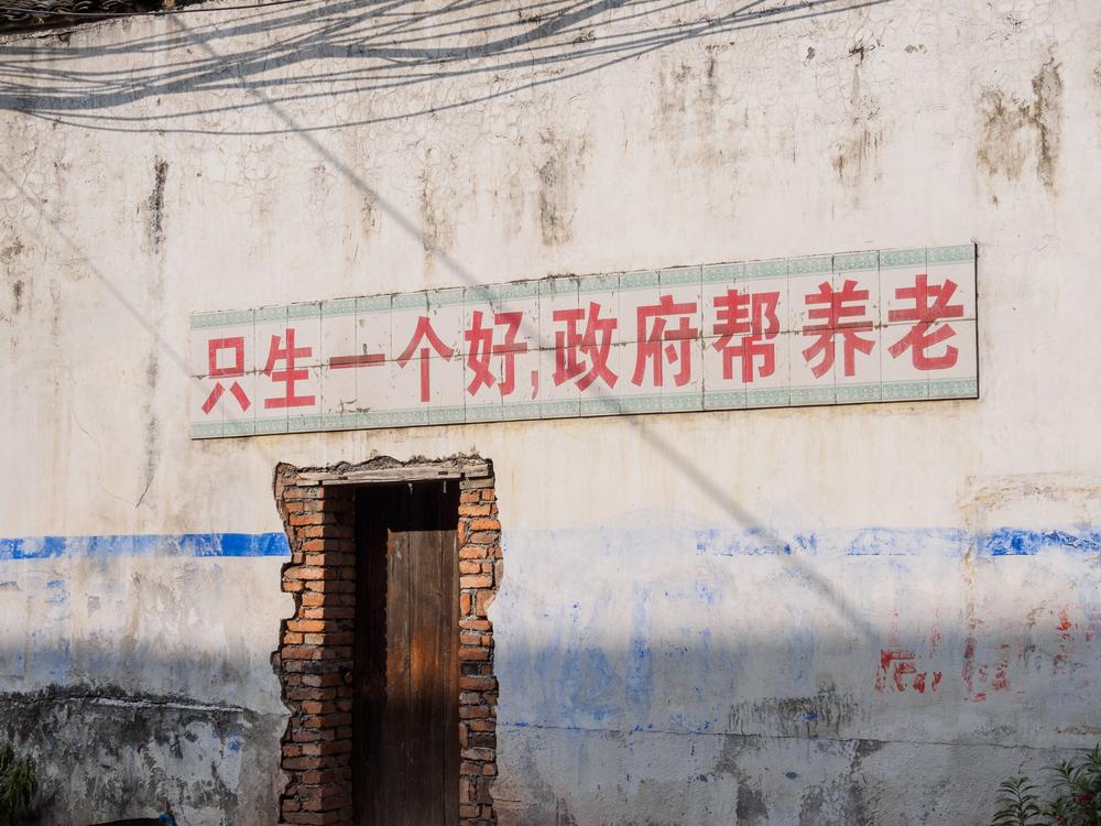 An old slogan on the wall in Jiande Village reads, "Have one baby and the government will provide for the aged." (atiger/Shutterstock)