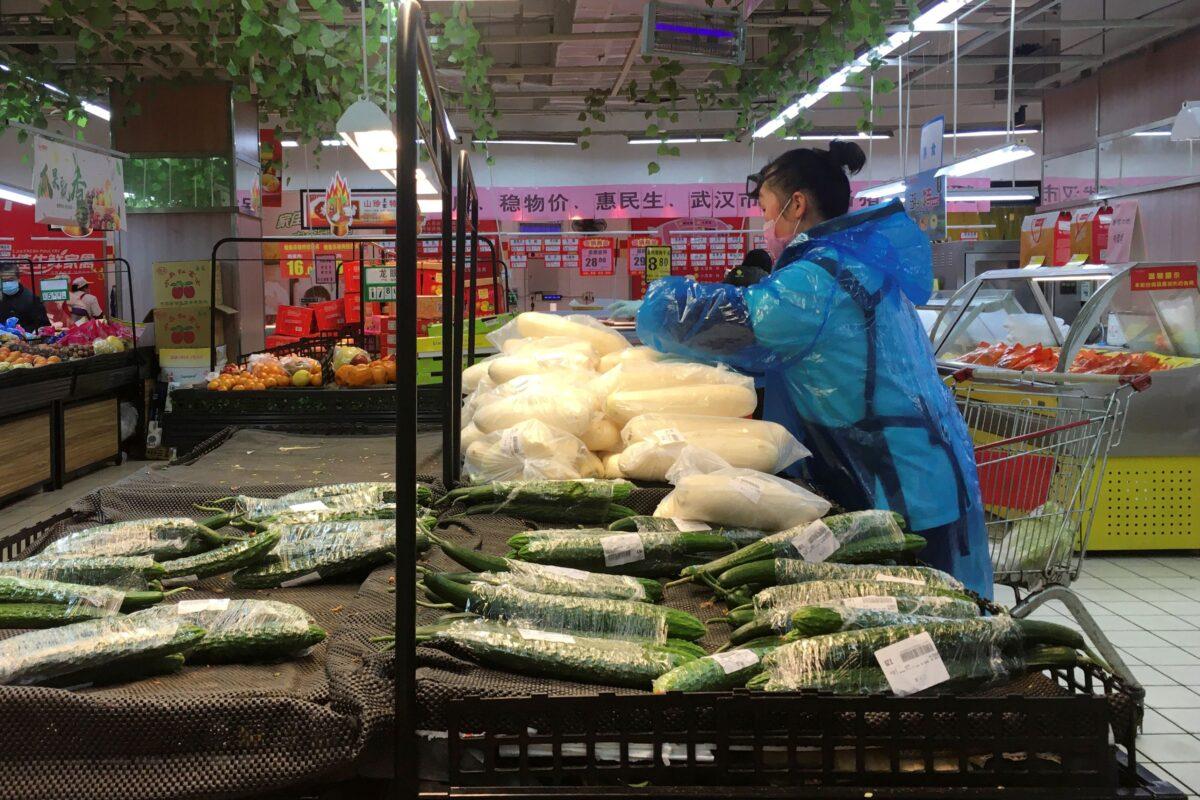 An employee sorts vegetables inside a supermarket in Wuhan, the epicentre of the novel coronavirus outbreak, in Hubei province, China on Feb. 14, 2020. (Stringer/Reuters)