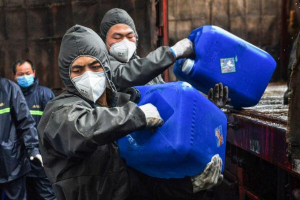 Chinese paramilitary police officers wearing protectieve gears transfer pails of disinfectant in Yunmeng county, outside Xiaogan City in China's central Hubei province on Feb. 12, 2020. (STR/AFP via Getty Images)