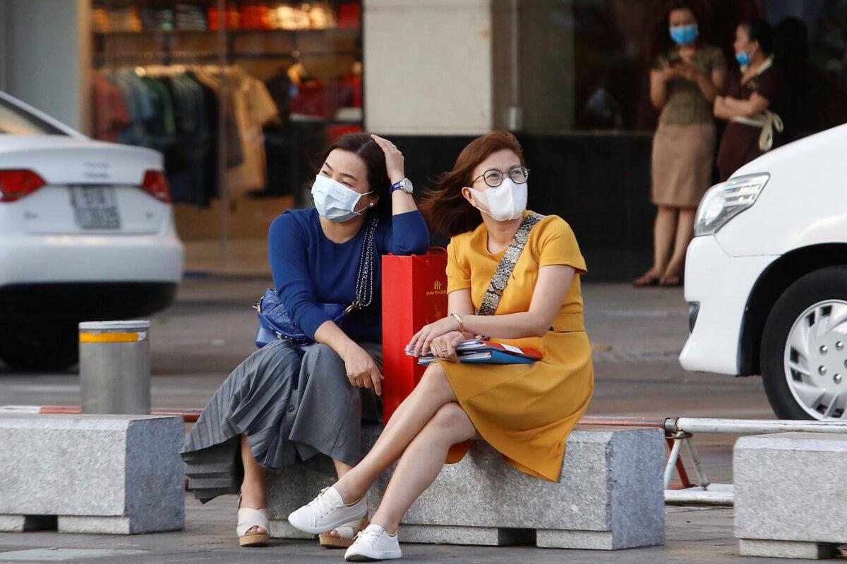 Women sit in a street as they wear face masks in Ho Chi Minh, Vietnam, on Feb. 13, 2020. (Yen Duong/Reuters)