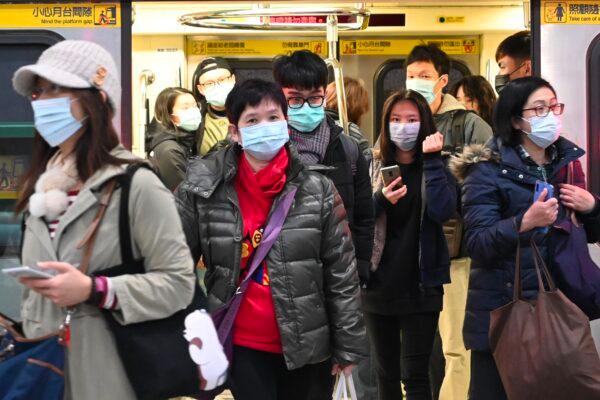 Mask-clad commuters get off a train at a Mass Rapid Transit (MRT) stop in Taipei, Taiwan, on Jan. 30, 2020. (Sam Yeh/AFP via Getty Images)