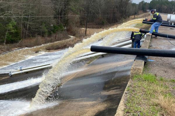Crews work to replace drainage pipes at the Oktibbeha County Lake dam in Starkville, Miss., as heavy rains cause water levels to rise, on Feb. 11, 2020. (Ryan Phillips/The Starkville Daily News via AP)