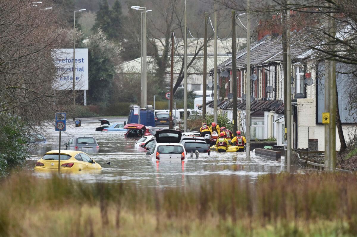A member of the public is rescued after flooding in Nantgarw, Wales, on Feb. 16, 2020. (Ben Birchall/PA via AP)