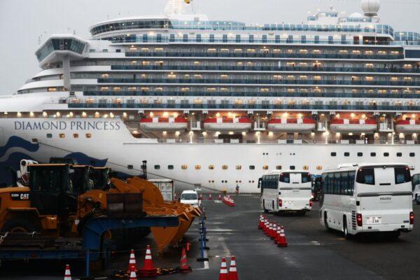 Two buses arrive next to the Diamond Princess cruise ship, with people quarantined onboard due to fears of the new coronavirus, at the Daikaku Pier Cruise Terminal in Yokohama port in Japan on Feb. 16, 2020. (Behrouz Mehri/AFP via Getty Images)